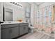 Bathroom with gray vanity, shower/tub combo, and nautical-themed shower curtain at 5047 Meadow Song Dr, Okahumpka, FL 34762