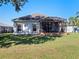 Home's exterior showcasing a screened patio and lawn at 5620 Squires Dr, Leesburg, FL 34748