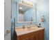 Bathroom with light blue walls, wood vanity, and a shower/tub combo at 712 Tarrson Blvd, The Villages, FL 32159