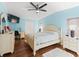 Bedroom with light blue walls and ceiling fan, featuring a queen-size bed and wood flooring at 712 Tarrson Blvd, The Villages, FL 32159