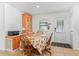 Small dining area with an orange hutch and wooden table and chairs at 712 Tarrson Blvd, The Villages, FL 32159