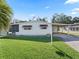 Single-wide manufactured home with carport and well-maintained lawn at 712 Tarrson Blvd, The Villages, FL 32159