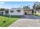 Front view of a single-wide manufactured home with paved driveway at 712 Tarrson Blvd, The Villages, FL 32159