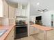Modern kitchen with black appliances and pinkish countertops at 712 Tarrson Blvd, The Villages, FL 32159
