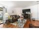 Bright living room featuring hardwood floors, large TV, and comfy seating at 712 Tarrson Blvd, The Villages, FL 32159