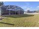 Large backyard with grassy area and screened pool at 7715 Indian Ridge N Trl, Kissimmee, FL 34747
