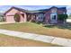 Brick and shingle ranch home with a two-car garage and landscaped yard at 7715 Indian Ridge N Trl, Kissimmee, FL 34747