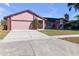 Brick and shingle ranch home with a two-car garage and driveway at 7715 Indian Ridge N Trl, Kissimmee, FL 34747