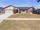 Brick and shingle ranch home with a two-car garage and landscaped yard at 7715 Indian Ridge N Trl, Kissimmee, FL 34747
