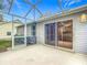 Screened-in patio with sliding glass doors and concrete flooring at 108 Costa Mesa Dr, Lady Lake, FL 32159