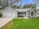 Front exterior of a gray home with white trim, attached two-car garage, and grassy front yard at 108 Costa Mesa Dr, Lady Lake, FL 32159