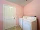 Laundry room with washer, dryer, and pink walls at 108 Costa Mesa Dr, Lady Lake, FL 32159