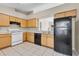 Kitchen with wood cabinets, black appliances, and tile floor at 12151 Woodglen Cir, Clermont, FL 34711