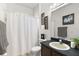 Clean bathroom with dark vanity, white toilet, and white shower curtain at 14701 Timucua Pl, Clermont, FL 34711