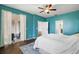 Bright bedroom with teal walls, ceiling fan, and access to the bathroom at 14701 Timucua Pl, Clermont, FL 34711