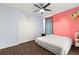 Bright bedroom with a large bed, pink wall, and ceiling fan at 14701 Timucua Pl, Clermont, FL 34711