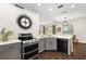 Modern kitchen with stainless steel appliances, gray cabinets, and quartz countertops at 14701 Timucua Pl, Clermont, FL 34711