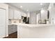 Modern kitchen with white and gray cabinets, quartz countertops, and stainless steel appliances at 14701 Timucua Pl, Clermont, FL 34711