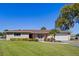 Ranch style home with brick exterior, landscaping and a long driveway at 1621 Texas Ct, Tavares, FL 32778
