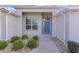 Inviting front entry with a blue door and landscaping at 2249 Quincy Ct, The Villages, FL 32162