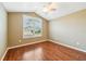 Bright bedroom with wood-look floors and large window with shutters at 2380 Bachman Path, The Villages, FL 32162