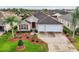 Single-story home with two-car garage, landscaping, and a large driveway at 2380 Bachman Path, The Villages, FL 32162