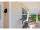 Covered porch with two metal chairs and a side table at 25004 Cranes Roost Cir, Leesburg, FL 34748