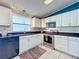 Kitchen with white cabinetry, black countertops, stainless steel appliances, and window above sink at 25007 Bellevue, Leesburg, FL 34748