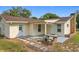 House exterior with covered patio, stone accents, and landscaping at 25544 Creston Ave, Sorrento, FL 32776