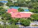 Community clubhouse with red roof and surrounding trees at 26613 Racquet Cir, Leesburg, FL 34748