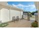 Relaxing patio with seating, stone wall, and view of trees at 26613 Racquet Cir, Leesburg, FL 34748