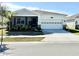 One-story home with light-colored siding, white garage door, and landscaping at 34004 Sky Blossom Cir, Leesburg, FL 34788