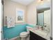 Clean bathroom with granite countertop and teal-painted lower walls at 3507 Vail Ct, The Villages, FL 32163