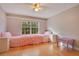 Charming bedroom with hardwood floors, large window, and pink bedding at 4236 Fawn Meadows Cir, Clermont, FL 34711