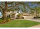 Two-story house with a three-car garage, manicured lawn, and mature landscaping at 4236 Fawn Meadows Cir, Clermont, FL 34711
