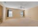 Large bedroom with neutral walls, ceiling fan, and carpet at 8021 Cardinal Winds Ln, Mascotte, FL 34753