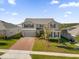 Aerial view of a two-story house with a gray exterior, brick driveway and landscaping at 1150 Blarney St, Minneola, FL 34715