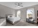 Bedroom with gray platform bed, large windows, and sitting area at 1150 Blarney St, Minneola, FL 34715