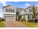 Two-story house with gray siding, brick driveway, and landscaping at 1150 Blarney St, Minneola, FL 34715