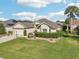 One-story house with beige exterior, two-car garage, and manicured lawn at 1589 Arial Pl, The Villages, FL 32162