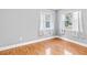 Bedroom with wood floors and two windows with curtains at 17469 Sw 35Th Avenue Rd, Ocala, FL 34473