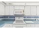 White appliances and cabinets are complemented by blue countertops and tile at 17469 Sw 35Th Avenue Rd, Ocala, FL 34473