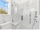 Spa-like bathroom with a walk-in shower, marble tile and built-in bench at 2051 Palo Alto Ave, The Villages, FL 32159