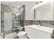 Elegant bathroom with marble shower, modern vanity and a frame mirror at 2051 Palo Alto Ave, The Villages, FL 32159