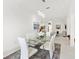 Open concept dining room with glass table and white chairs at 2051 Palo Alto Ave, The Villages, FL 32159