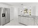 Modern kitchen, featuring stainless steel refrigerator and white cabinetry at 2051 Palo Alto Ave, The Villages, FL 32159