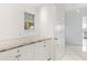 White cabinets and granite countertop in a galley style kitchen at 2051 Palo Alto Ave, The Villages, FL 32159