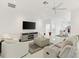 Spacious living room, featuring a gray sectional and flat-screen TV at 2051 Palo Alto Ave, The Villages, FL 32159