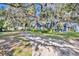 Long driveway leading to a charming blue house, lined by mature oak trees at 214 S Woodland St, Winter Garden, FL 34787