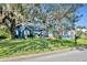 Quaint blue house with white trim and a spacious lawn, shaded by large oak trees at 214 S Woodland St, Winter Garden, FL 34787